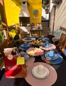 une table avec des assiettes de nourriture au-dessus dans l'établissement Recanto dos Pássaros, à Ilhabela