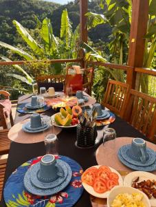 a table with plates of food on top at Recanto dos Pássaros in Ilhabela