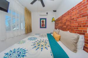 a bedroom with a bed with a brick wall at Hotel Suites Nadia Puerto Vallarta in Puerto Vallarta