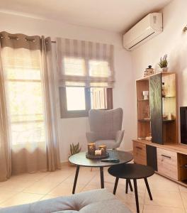 PORT SEA VIEW - SKIATHOS في مدينة سكياثوس: غرفة معيشة مع كرسي وطاولة