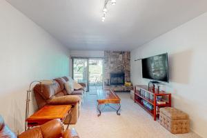 uma sala de estar com um sofá e uma televisão em Haus on Hole Five em Groveland