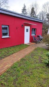 Casa roja con puerta blanca y patio en Appartement in Lychen mit Garten, Grill und Terrasse, en Lychen