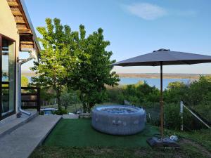 a patio with an umbrella and a hot tub at Weekendaya in Kladovo