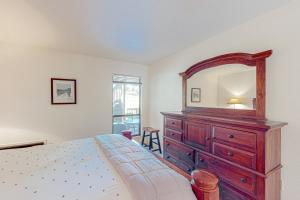 a bedroom with a wooden dresser and a mirror at Haus on Hole Five in Groveland