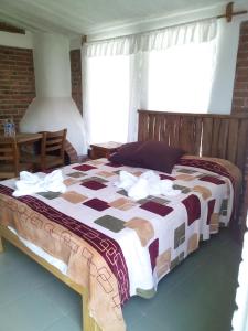 ein Schlafzimmer mit einem Bett mit einer braunen und weißen Decke in der Unterkunft Cabañas La Mision in Chignahuapan
