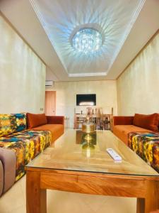 马拉喀什Superbe appartement en résidence avec piscines的客厅里有一张沙发和一张桌子。
