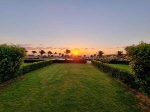 una puesta de sol sobre un parque con palmeras y césped en La Vista 6 Ain Sokhna Chaleh, en Ain Sokhna