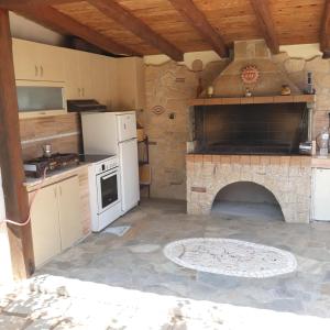 a kitchen with a stone fireplace in a room at Evdokia Country Maisonette in Áyios Mámas