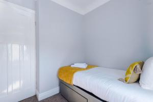 a bedroom with a bed with white walls and a window at Charming 3-Bedroom Home in Liverpool - FREE Parking in Deysbrook