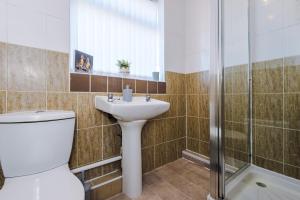 a bathroom with a toilet and a sink and a shower at Charming 3-Bedroom Home in Liverpool - FREE Parking in Deysbrook