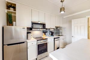 a kitchen with white cabinets and a stainless steel refrigerator at 7213 Flood Reef - Unit 2 in Pensacola