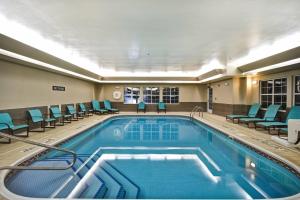 a pool in a hotel room with chairs around it at Residence Inn by Marriott Dayton Beavercreek in Beavercreek