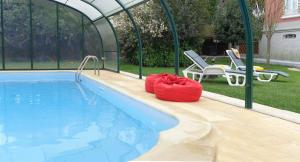 a swimming pool with a tent and chairs next to it at Casa do Sino de Aveiro in Estarreja