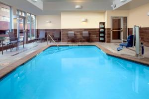 Fairfield Inn & Suites by Marriott Denver Tech Center North في دنفر: مسبح كبير مع ماء أزرق في غرفة الفندق