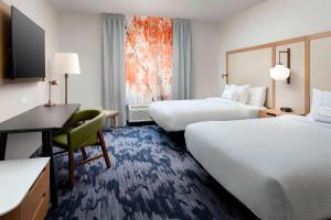 デンバーにあるFairfield Inn & Suites by Marriott Denver Tech Center Northのベッド2台とデスクが備わるホテルルームです。