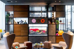a living room with chairs and a wall of windows at Moxy Glasgow SEC in Glasgow