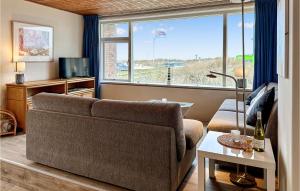 ein Wohnzimmer mit einem Sofa und einem großen Fenster in der Unterkunft Duinennest in Bergen aan Zee