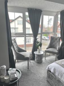 a bedroom with two chairs and a bed and a window at The Cresswell Inn in Skegness