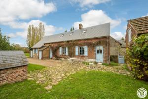 una vieja casa de ladrillo con un patio de hierba en Le Logis Bleu en Senantes