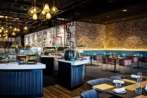 a restaurant with tables and chairs and a bar at Aloft Dubai Airport in Dubai