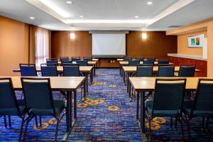 a conference room with tables and chairs and a whiteboard at Courtyard Cleveland Airport South in Middleburg Heights