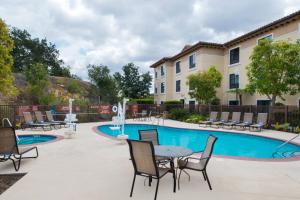 un patio con mesa y sillas junto a una piscina en TownePlace Suites Thousand Oaks Ventura County, en Thousand Oaks