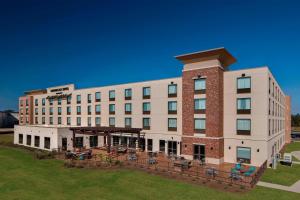 a hotel building with a lawn in front of it at TownePlace Suites by Marriott Foley at OWA in Foley