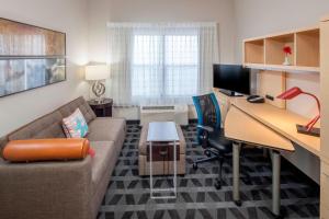a living room with a couch and a desk with a computer at TownePlace Suites Columbus in Columbus