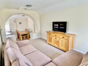 a living room with a couch and a flat screen tv at Bay View Apartment - Trearddur Bay in Trearddur