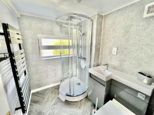 a bathroom with a shower and a toilet and a sink at Bay View Apartment - Trearddur Bay in Trearddur