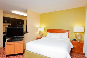 a bedroom with a bed and a flat screen tv at TownePlace Suites by Marriott Bloomington in Bloomington