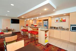uma grande cozinha com bancos de bar vermelhos num quarto em TownePlace Suites by Marriott Bloomington em Bloomington