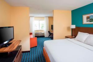 a hotel room with a bed and a flat screen tv at Fairfield Inn & Suites by Marriott Dayton South in Centerville