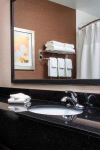 a bathroom with a sink and a mirror and towels at Fairfield Inn & Suites by Marriott Dayton South in Centerville