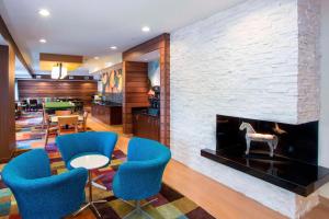 a living room with blue chairs and a fireplace at Fairfield Inn & Suites by Marriott Dayton South in Centerville