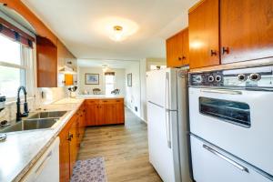 uma cozinha com electrodomésticos brancos e armários de madeira em Columbia City Vacation Rental with Lake Access em Columbia City