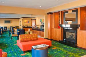 a hotel room with a fireplace and a living room at Fairfield Inn & Suites by Marriott Champaign in Champaign