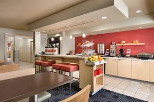 uma grande cozinha com paredes vermelhas e bancos vermelhos em TownePlace Suites Fort Lauderdale West em Fort Lauderdale