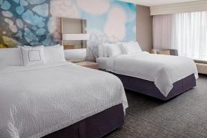 a hotel room with two beds and a mural at Courtyard Charlotte City Center in Charlotte