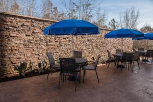 un patio avec des tables et des chaises et des parasols bleus dans l'établissement Fairfield Inn & Suites by Marriott Florence I-20, à Florence