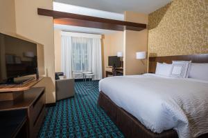 a hotel room with a large bed and a flat screen tv at Fairfield Inn & Suites by Marriott Florence I-20 in Florence