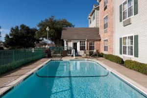 a swimming pool in front of a house at TownePlace Suites by Marriott College Station in College Station