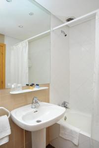 W łazience znajduje się umywalka, wanna i lustro. w obiekcie AS Hoteles Altube w mieście Zuia