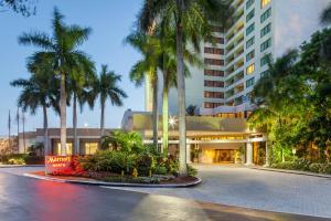 a building with palm trees in front of a street at Fort Lauderdale Marriott North in Fort Lauderdale