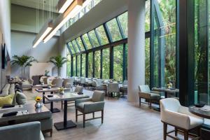 a restaurant with tables and chairs and large windows at Fort Lauderdale Marriott North in Fort Lauderdale