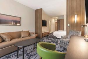 ein Hotelzimmer mit einem Sofa und einem Bett in der Unterkunft Fairfield Inn & Suites by Marriott Kansas City Shawnee in Shawnee