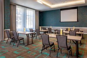 a conference room with tables and chairs and a whiteboard at Residence Inn by Marriott Boston Cambridge in Cambridge