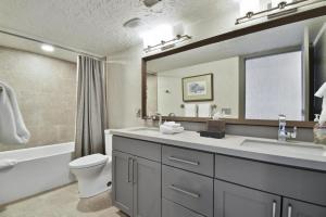 een badkamer met een wastafel, een toilet en een spiegel bij Temptation #7 in Park City +16 foto's