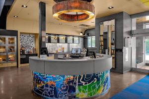 a lobby with a reception counter in a building at Aloft Chapel Hill in Chapel Hill