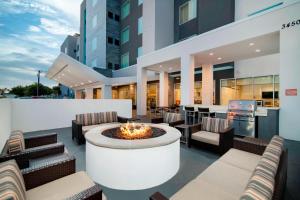 a patio with a fire pit and chairs and a building at TownePlace Suites Fort Worth University Area/Medical Center in Fort Worth